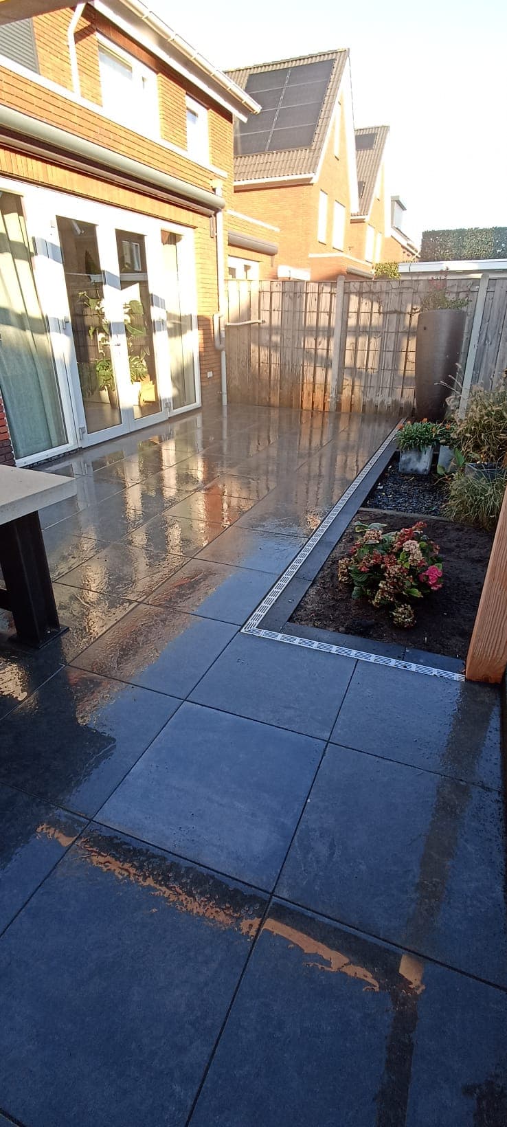 Anthracite porcelain terrace with white slot drain and hydrangea bed