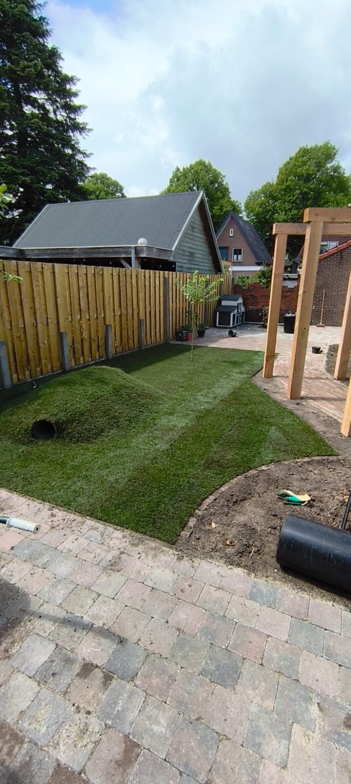 Fresh sod lawn with a play mound along a new pine fence