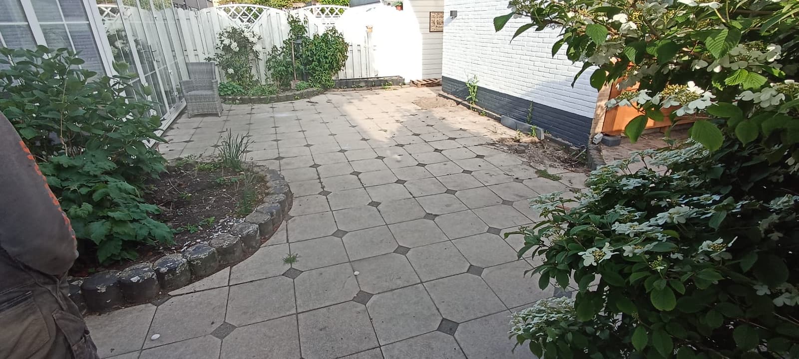 The old garden before works: worn octagonal paving and overgrown beds